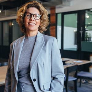 Woman with glasses and suit smiling