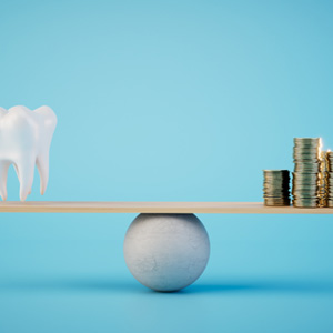 Model of tooth and coins on wooden plank balanced on ball