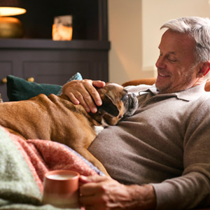 Man relaxing at home and petting his dog