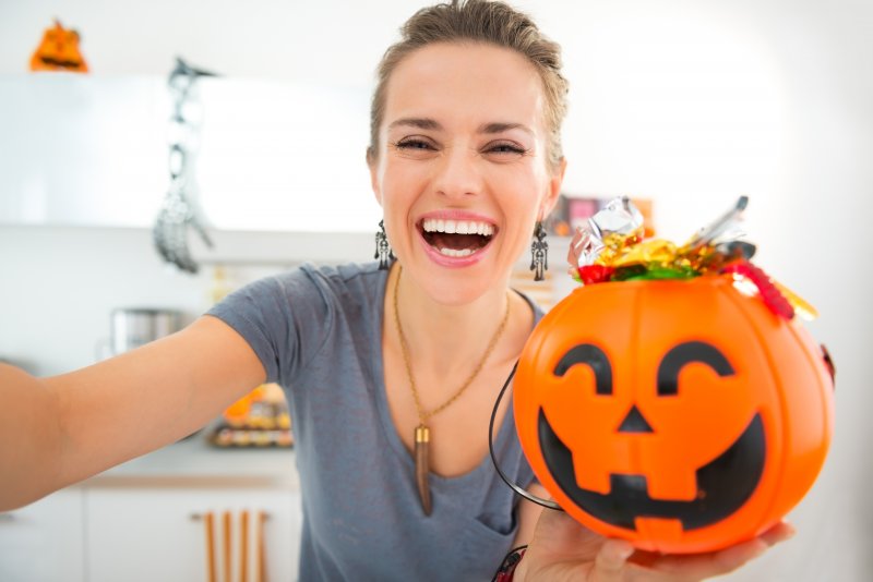 woman smiling and holding Halloween candy 